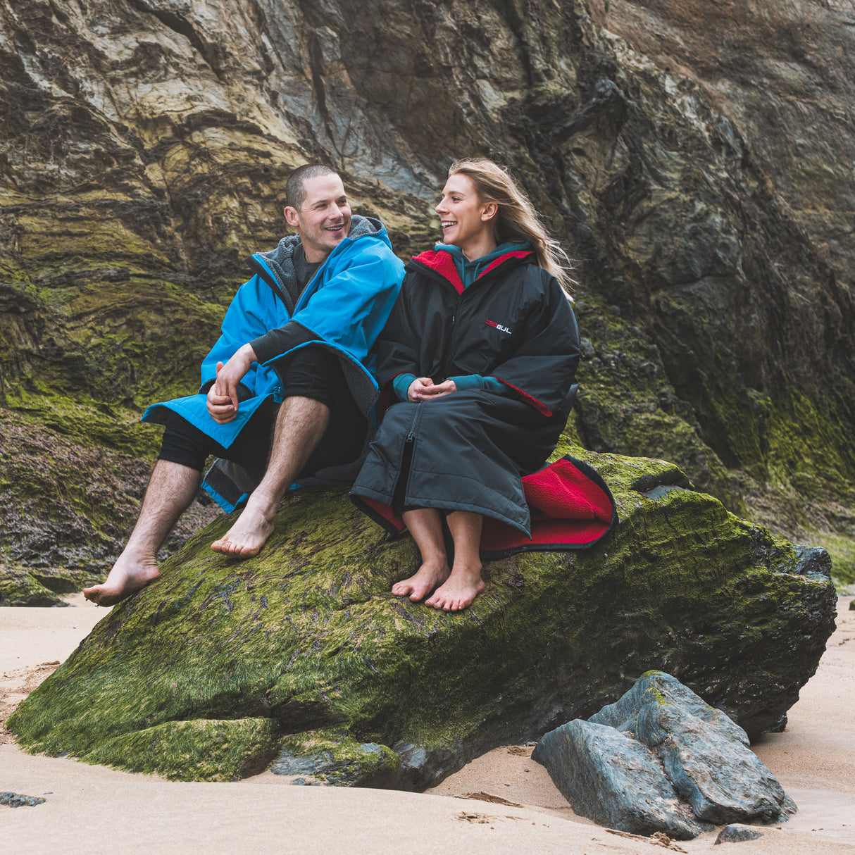 Gul EVORobe Hooded Changing Robe Black | Lifestyle sitting on the Rocks