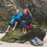 Gul EVORobe Hooded Changing Robe Black | Lifestyle sitting on the Rocks